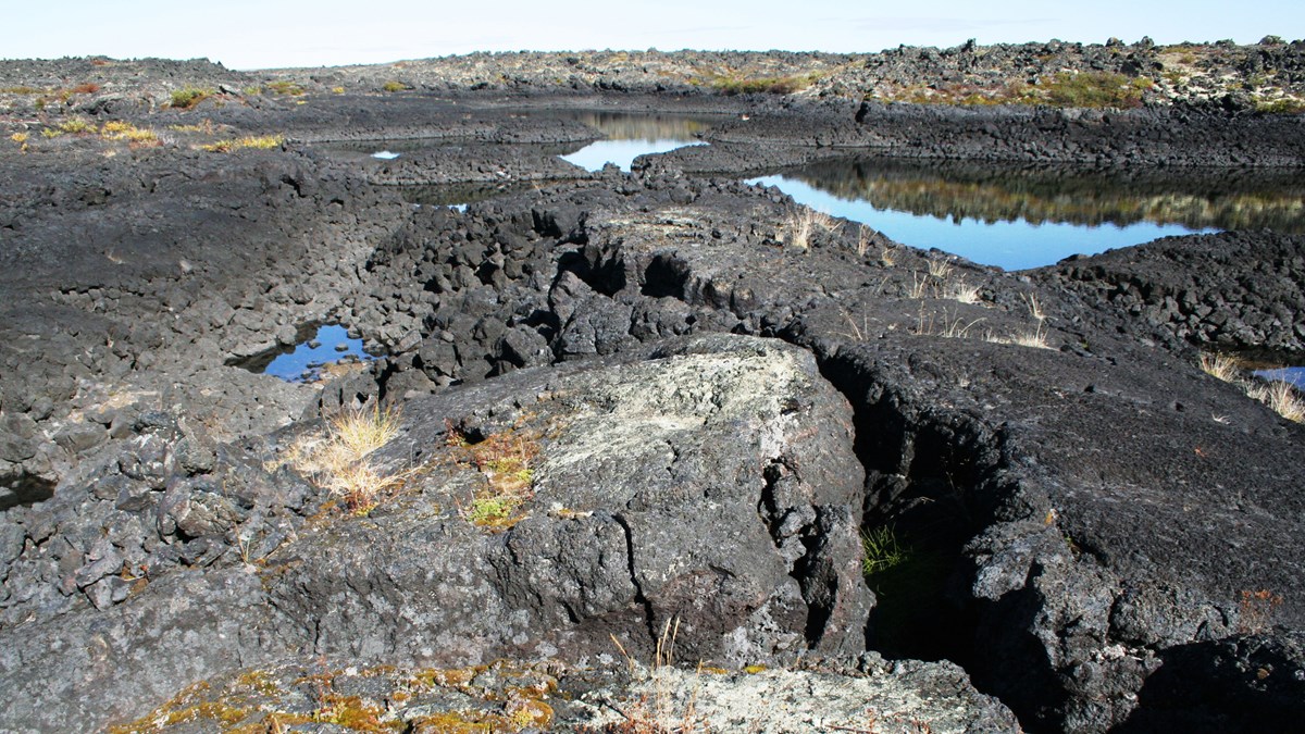 Dark lava flow with rain ponds in depressions