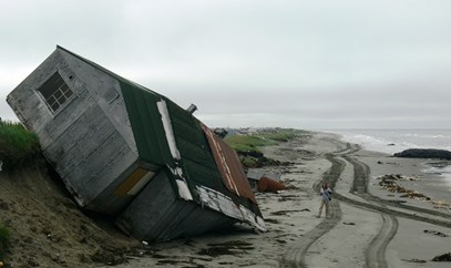 A house that has fallen off an eroded shoreline onto the beach in Shishmaref