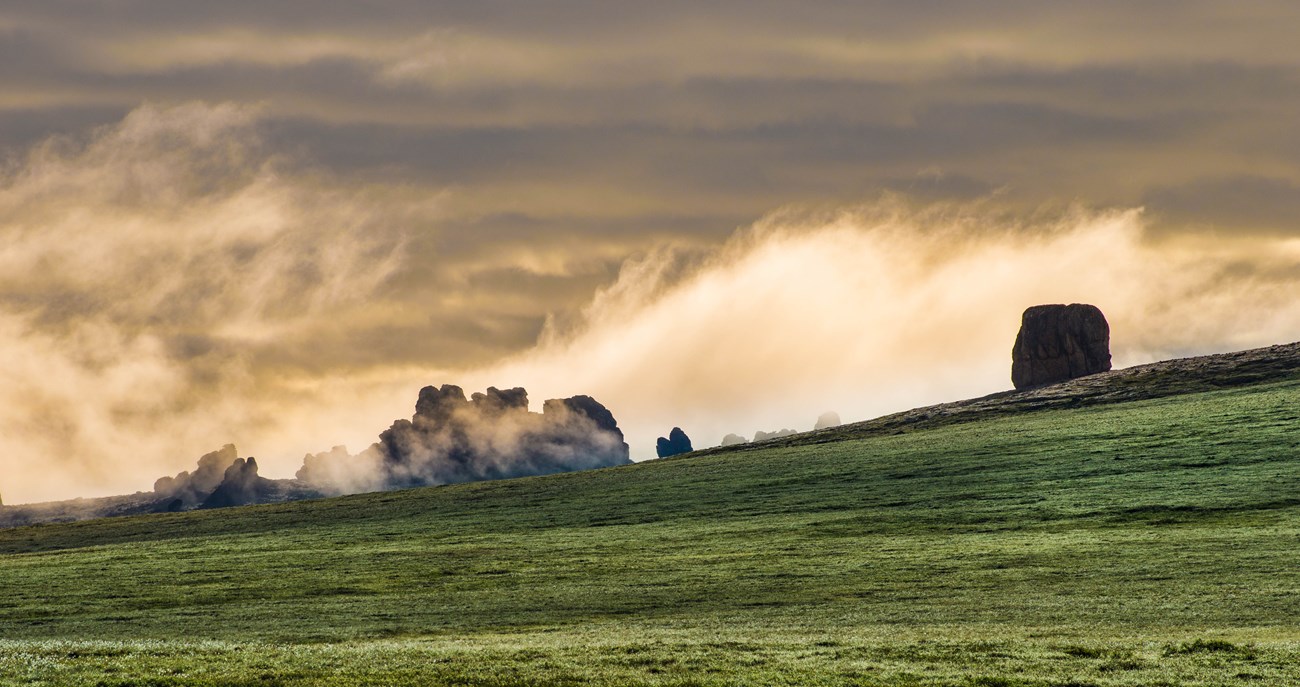 Low hanging clouds enshroud a cluster of tors.