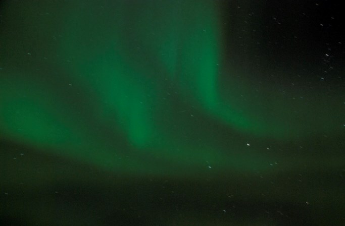 Three ribbons of green northern lights sweep across the night sky Three ribbons of green northern lights sweep across the night sky