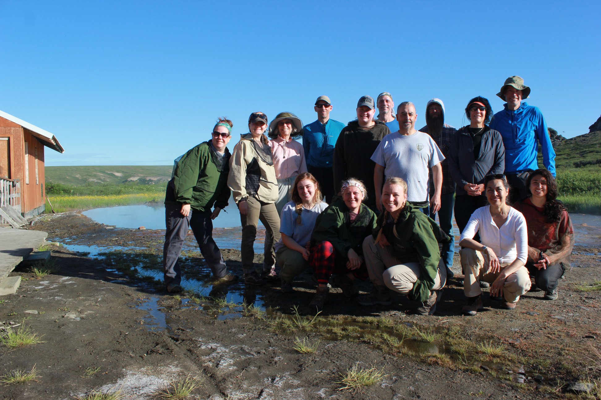 A group of people pose for a picture on a bright sunny day.