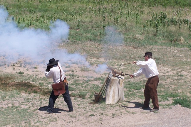 Two men fire a swivel gun