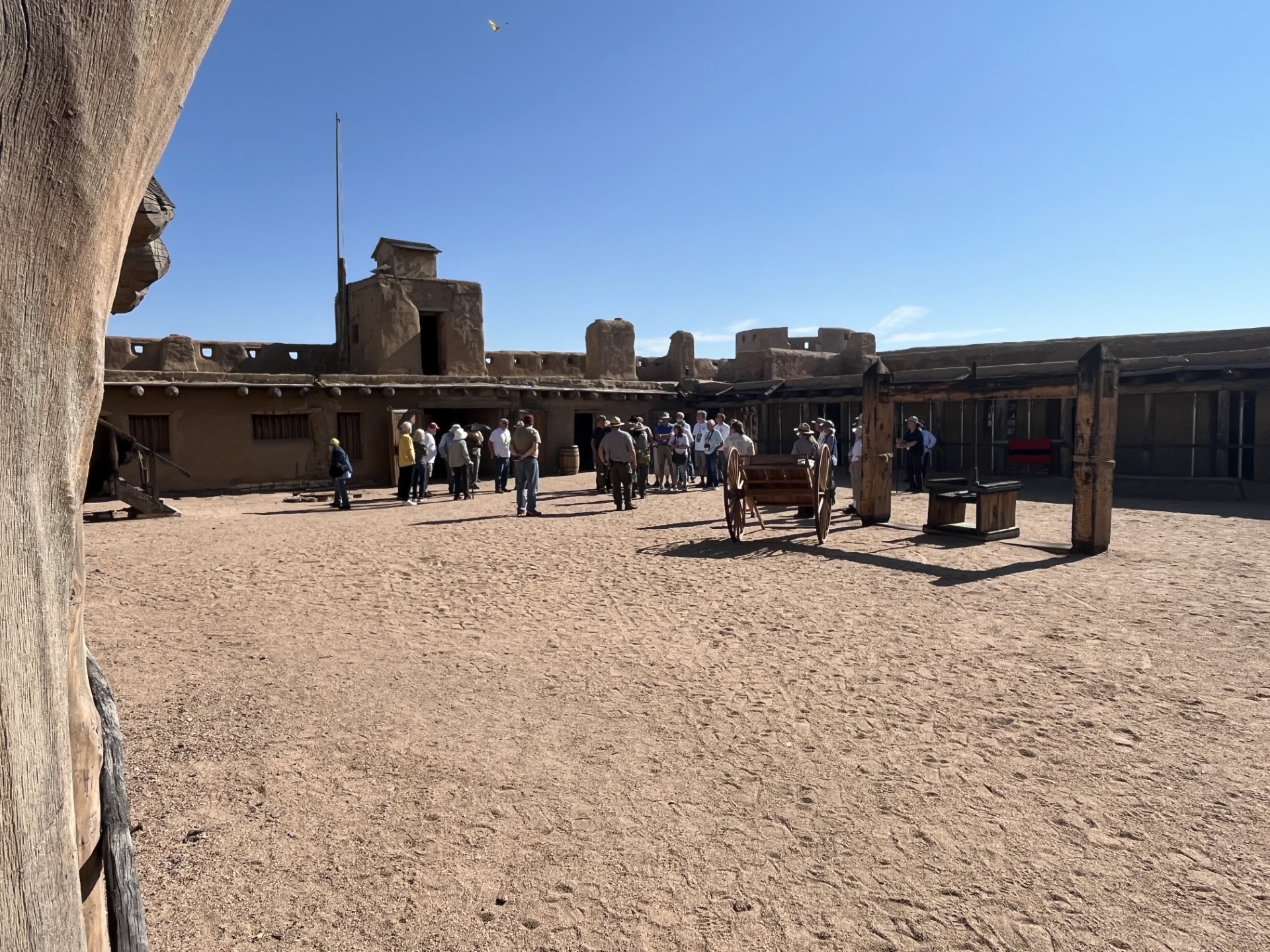 Park rangers speak to a group of visitors inside the plaza of a large building.