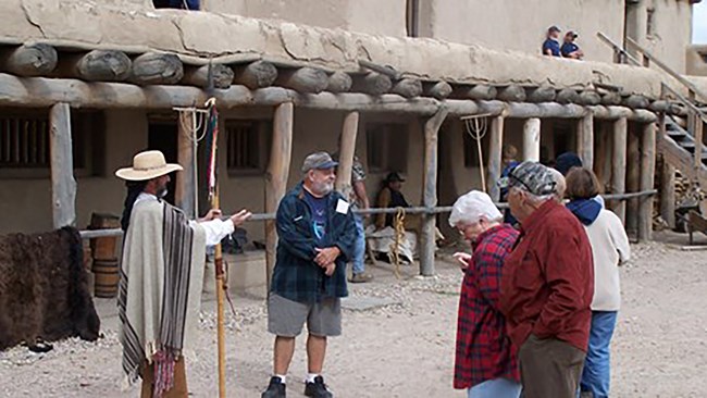 Interpreter, dressed in period clothing, presenting guided tour for visitors