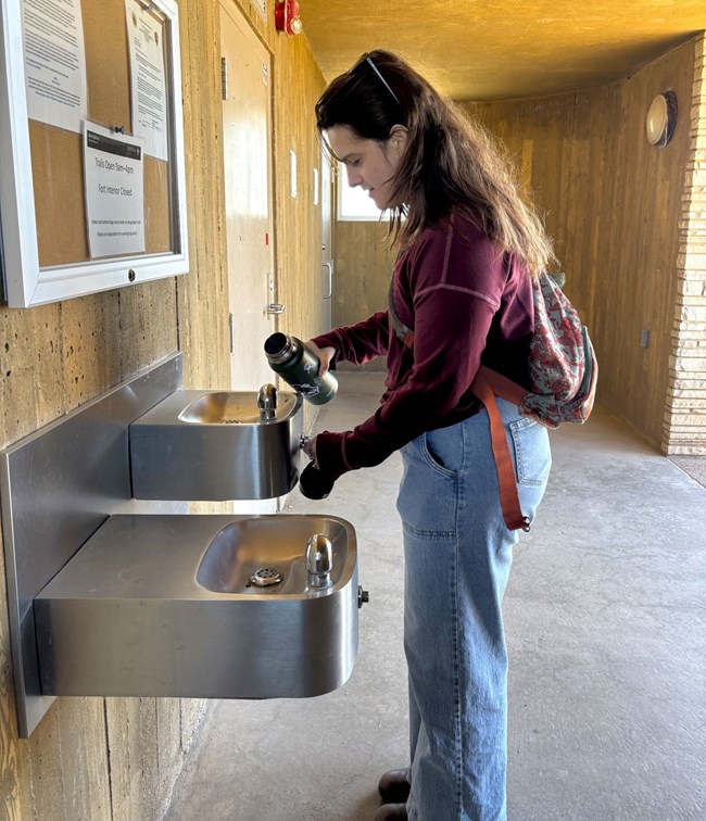 visitor fills water bottle at water fountain