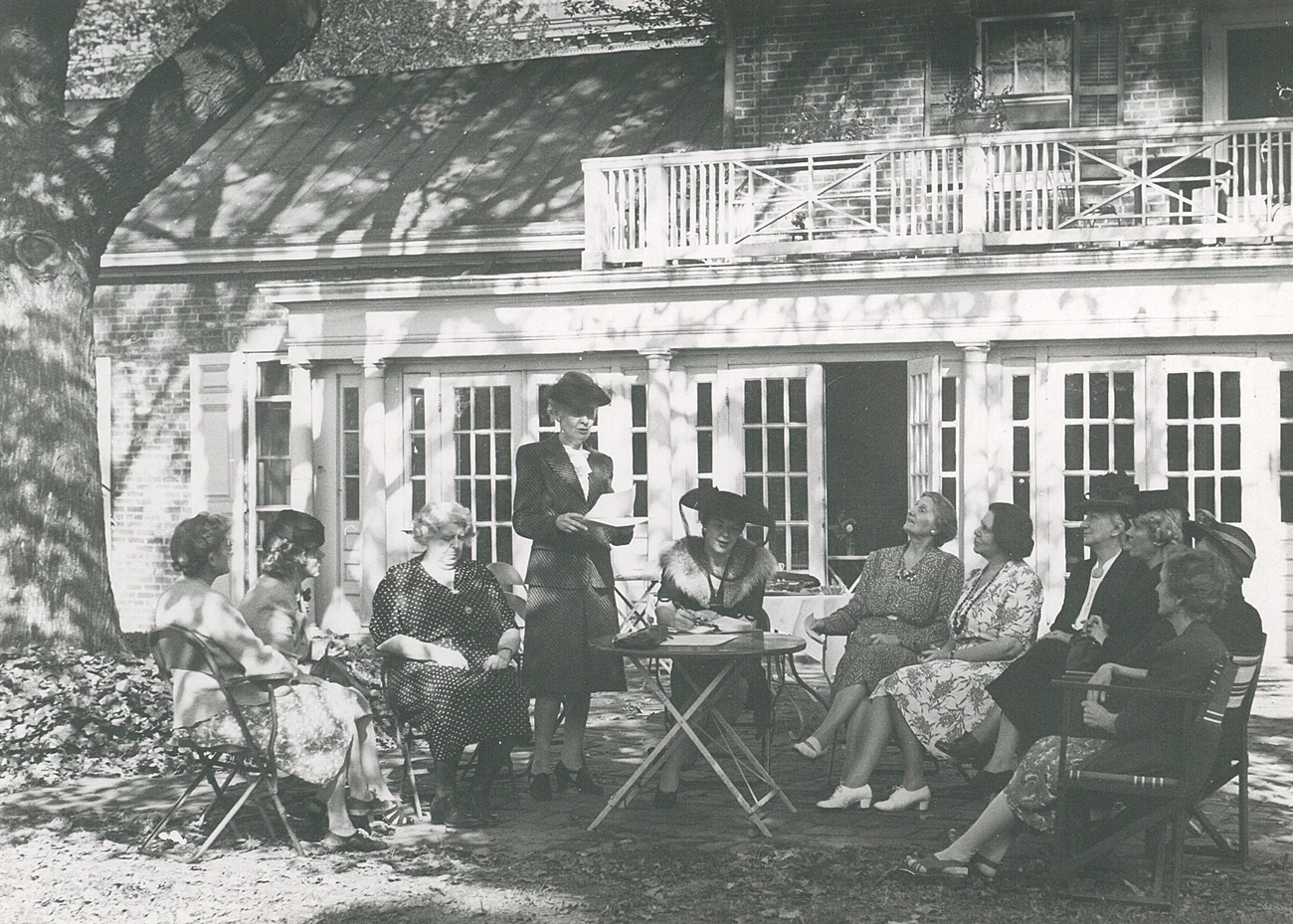 Garden_1943.001.002_cropped Ten women seated and one standing outside Belmont House for meeting
