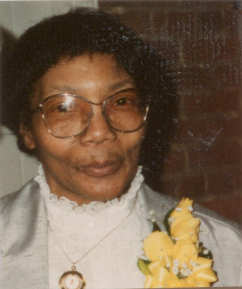 Close up photo of Letha Mae Glover wearing a corsage on her suit jacket with a high necked blouse