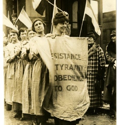 Resistance to Tyranny Prison Special A line of women in prison dress in a train station. The first holds a banner reading "Resistance to Tyranny is Obedience to God"