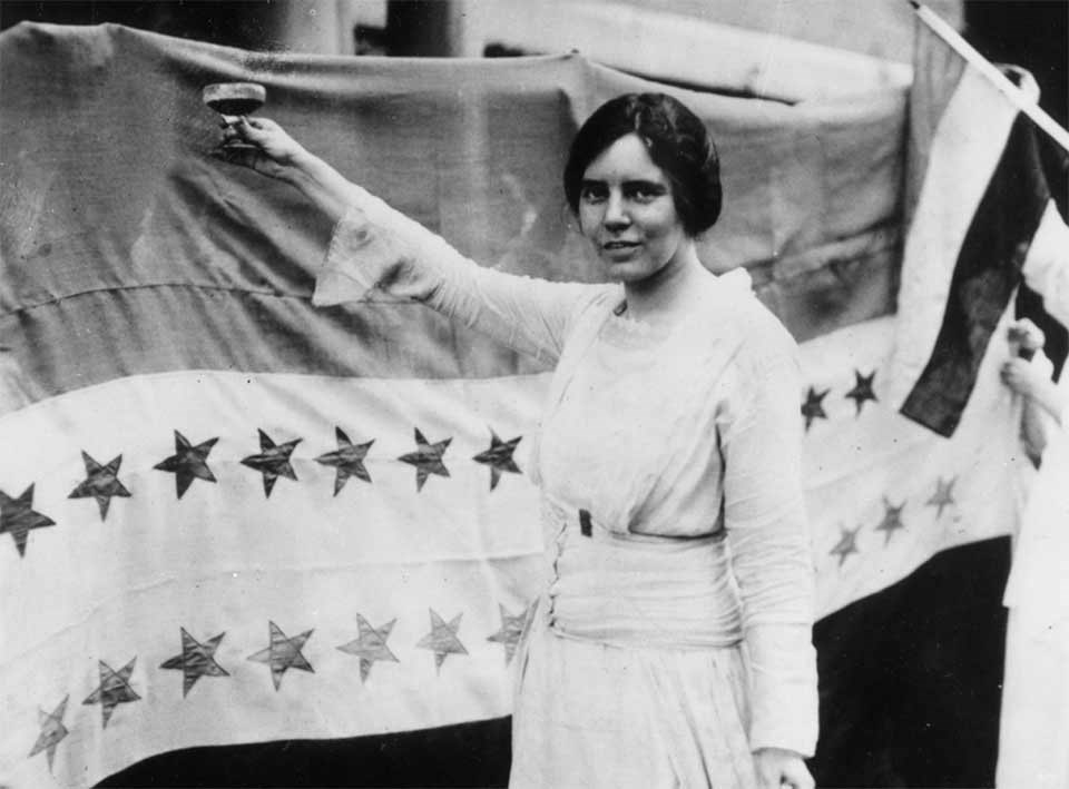 Alice Paul raises glass in front of Victory Star Banner