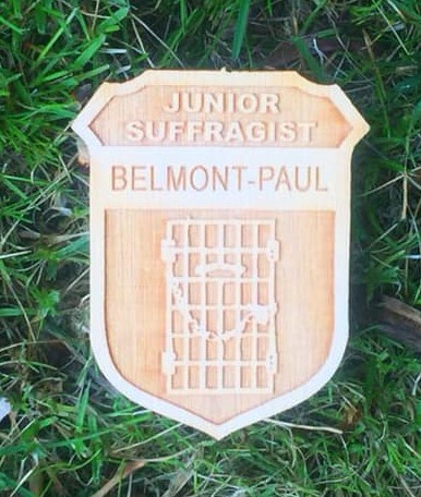 Wooden Junior Suffragist badge in the grass