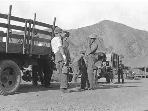 Young men take a break from road work in a 1930s photo.