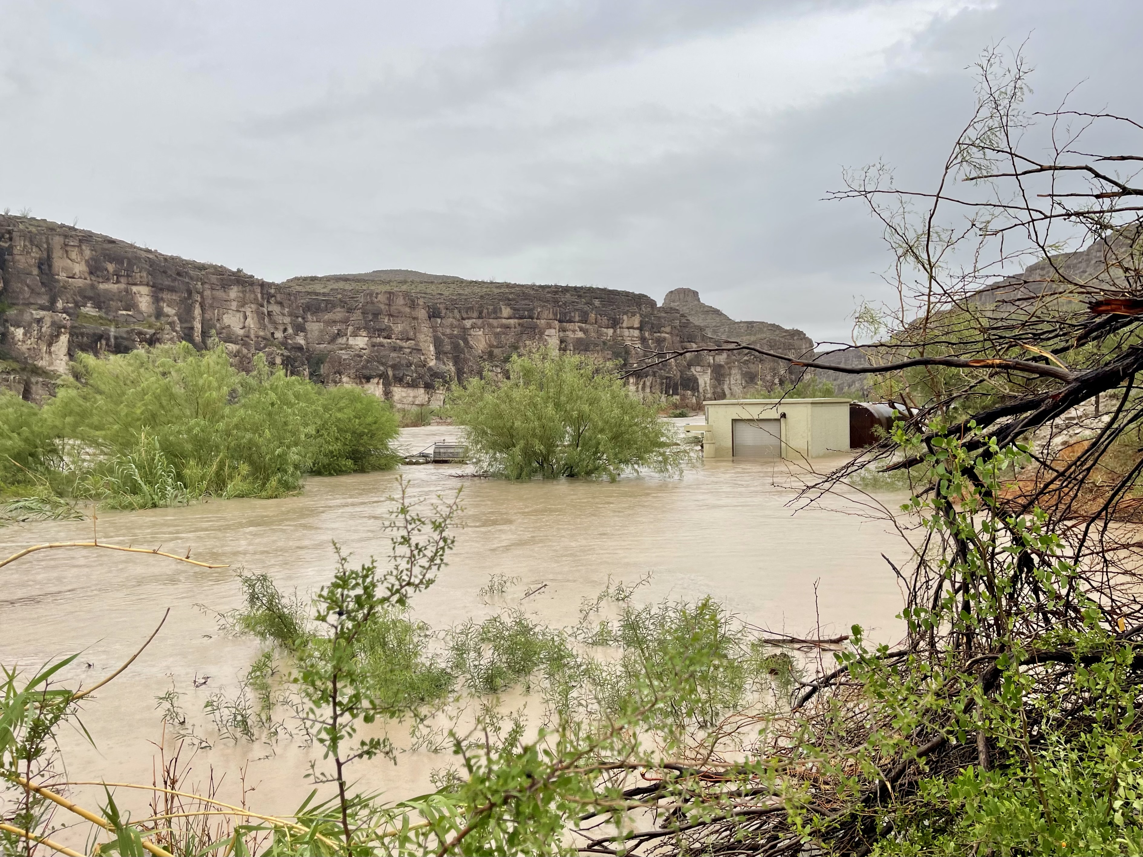 BIBE_RGVPumpHouse_Flooding_courtesyofKateLentz_2025July3 A building is almost submerged beneath flood waters.