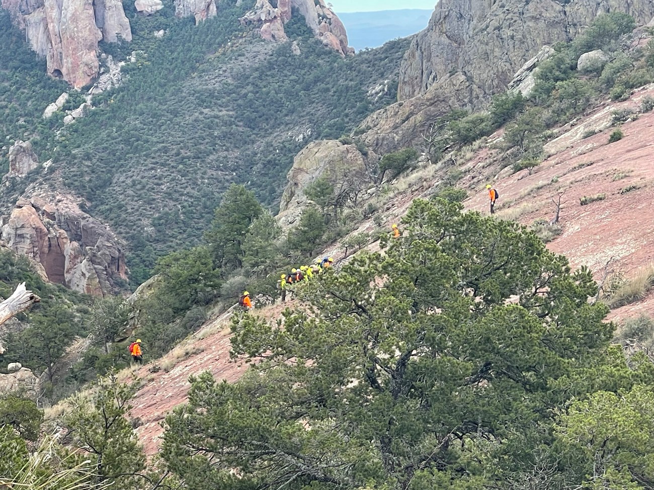 Rescuers negotiating steep terrain with the patient.