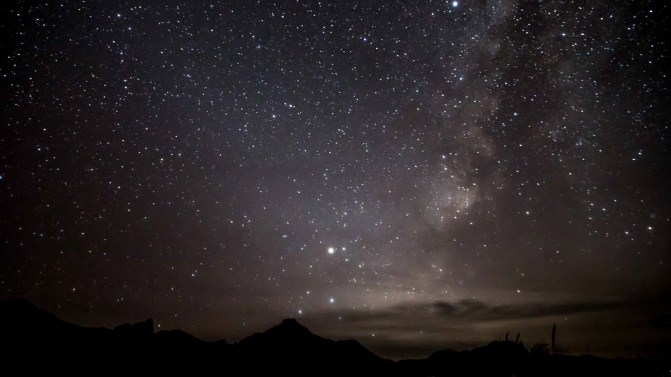 Milky Way Over The Chisos Mountains A sky filled with stars towers over the desert landscape.