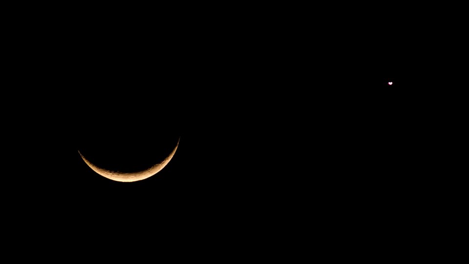 A crescent moon shares photo with a star