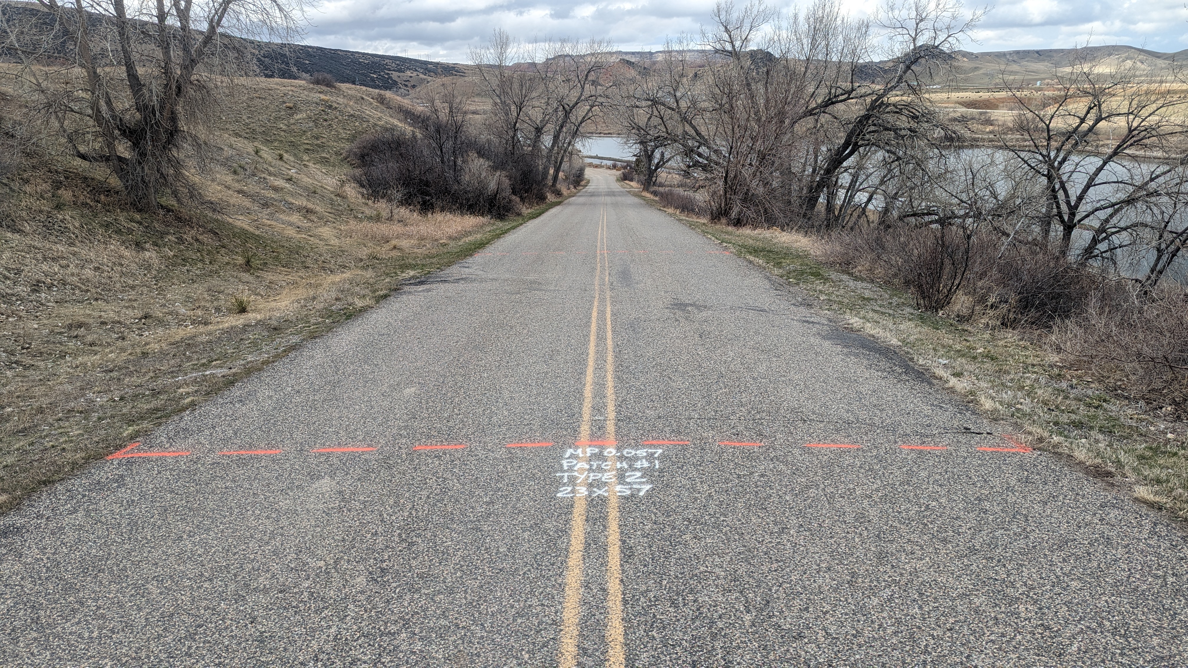 Orange lines mark out where new asphalt will be placed during summer construction along the main road to the Afterbay Campground at Bighorn Canyon National Recreation Area.