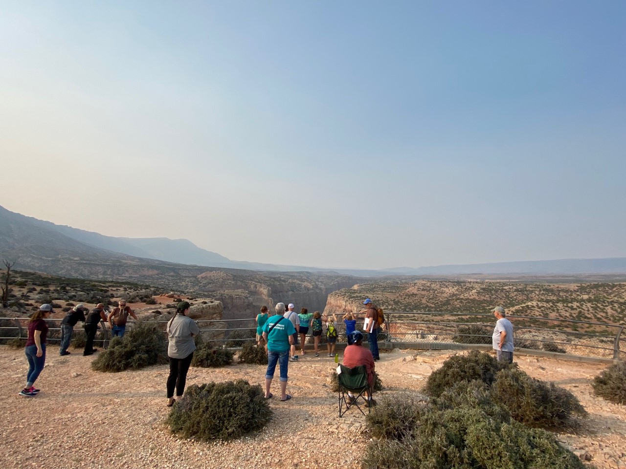 Geology Talk at Devil Canyon Overlook Several visitors are spread out listening to volunteer Greg discuss geology with the canyon overlook view in the background.