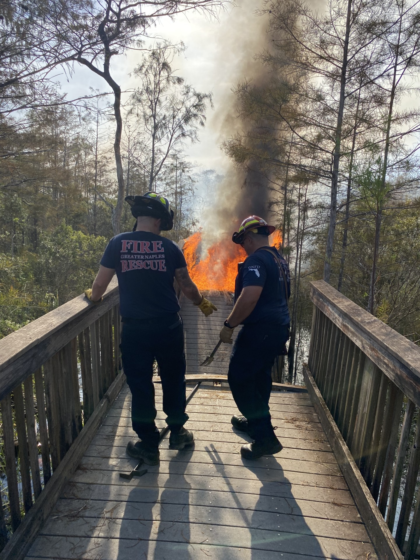 Kirby Fire Photo Two wildland firefighters work to put out flames on Kirby Storter Boardwalk