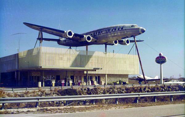 a building with an airplane on posts above it