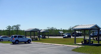 Several cars parked near shaded picnic tables at Kirby Storter Park.