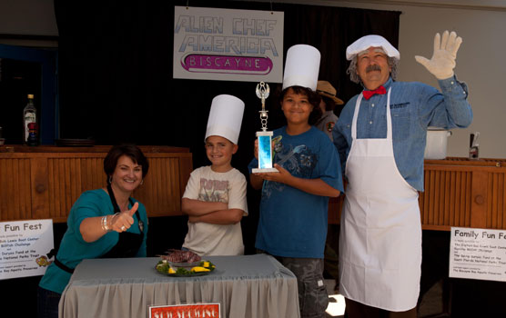Rachel Stingray, The Swedish Chef and their two sous chefs pose with a lionfish on the set of "Alien Chef America."