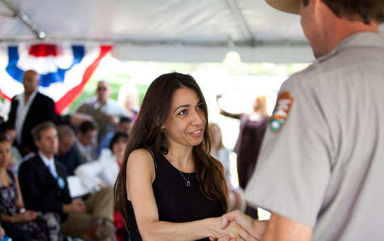 A new citizen receives congratulations from a park ranger.