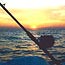 A fishing rod awaits use at sunset