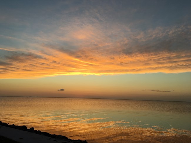 Orange clouds reflected in the water.