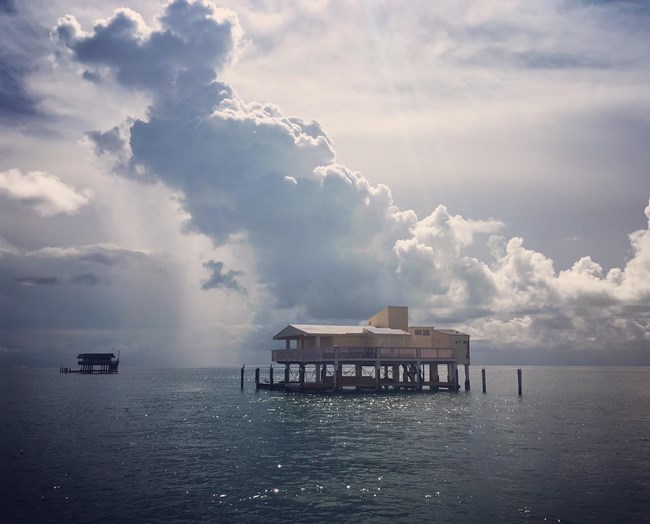 A house built on stilts raised above the waters of the bay.