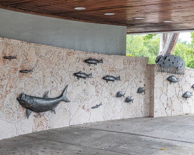 Fish Wall shows bronze fish against a white wall