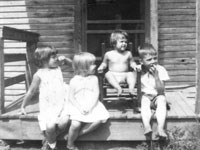 Small children sitting on a front porch. Small children sitting on a front porch.