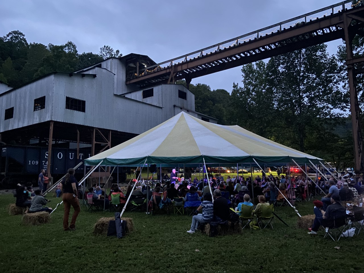 A large outdoor tent filled with seated attendees at dusk during a past Ghost Mine event.