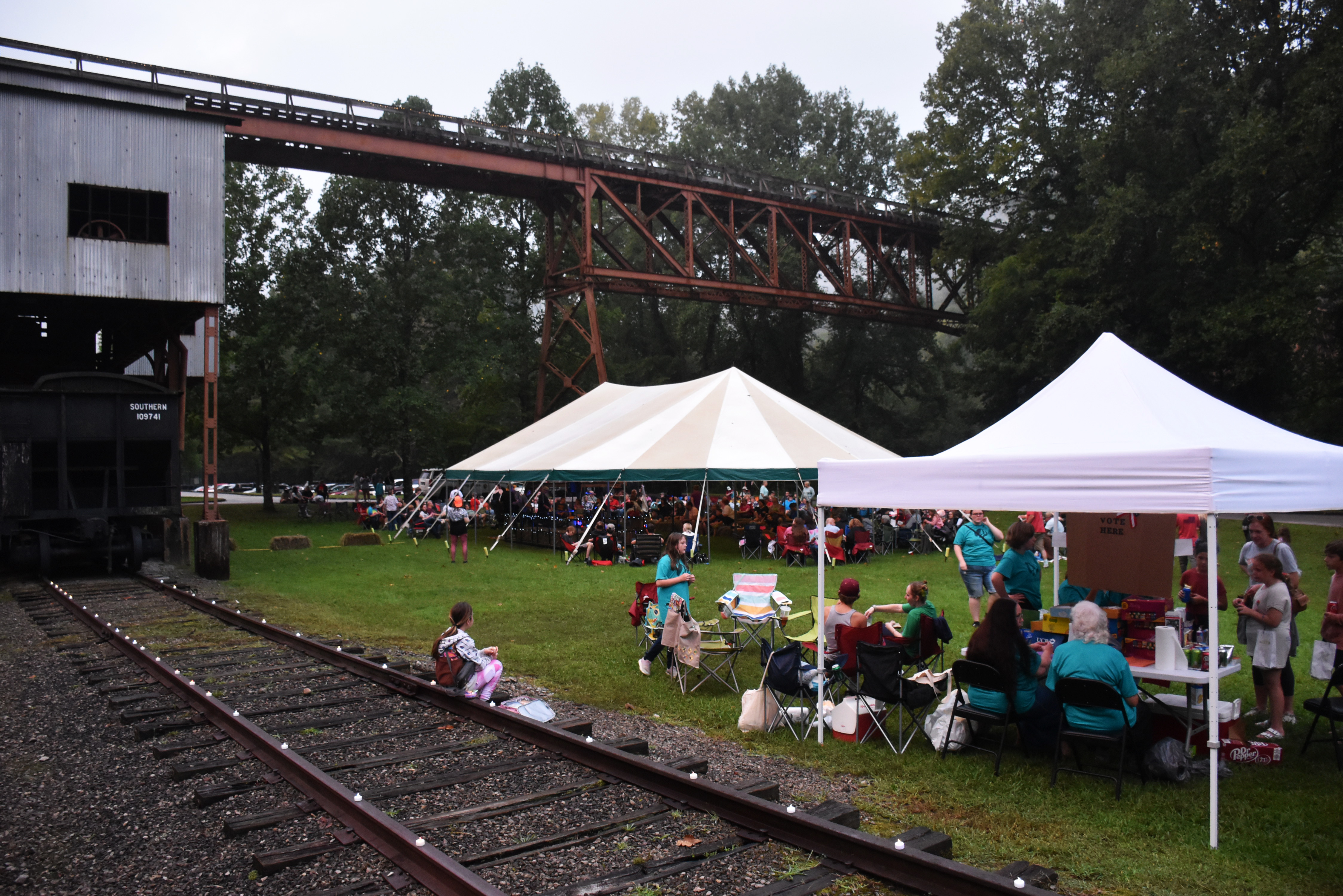 Two giant white tents under a coal tipple structure.