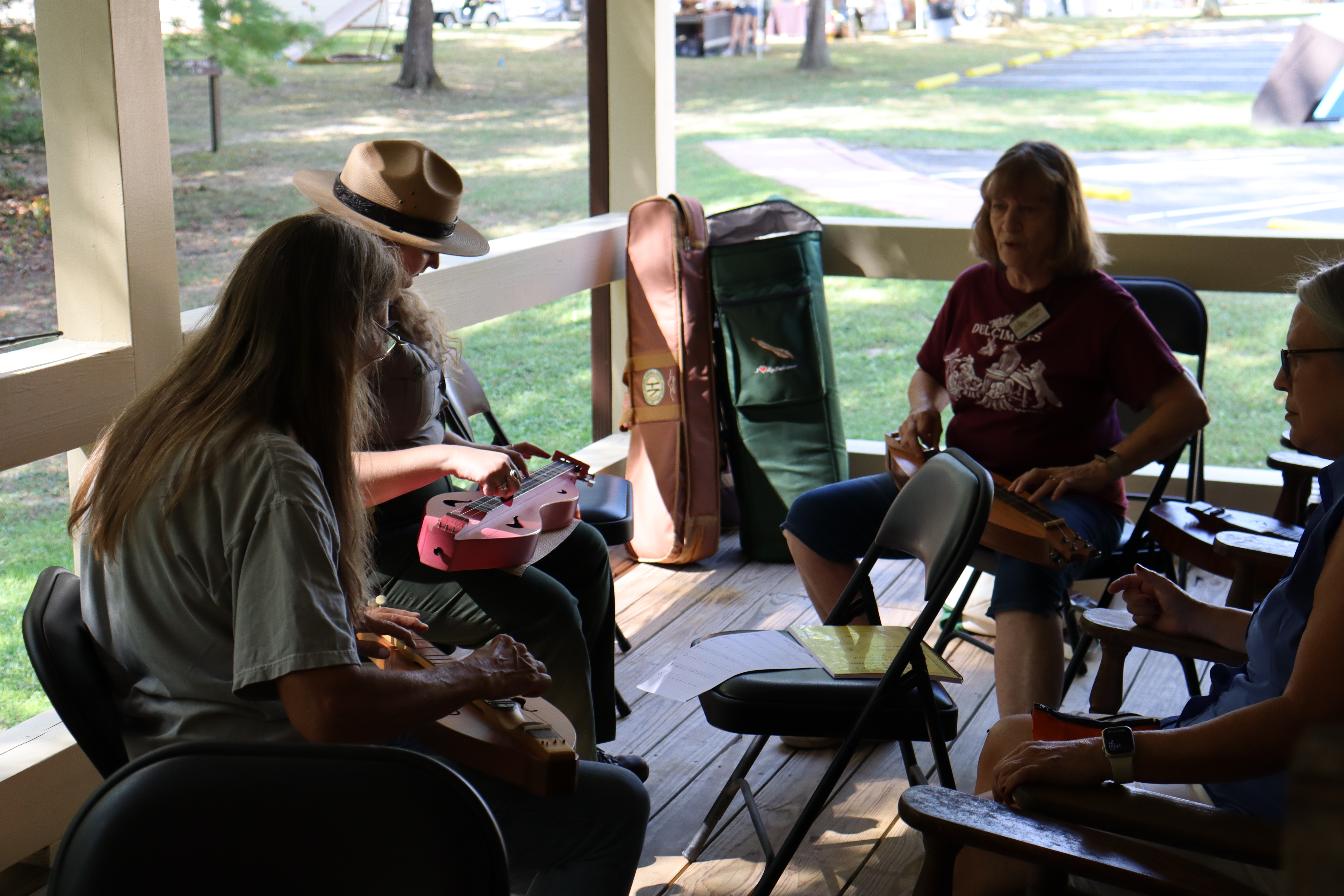 A group of people sitting down for a dulcimer lesson workshop.
