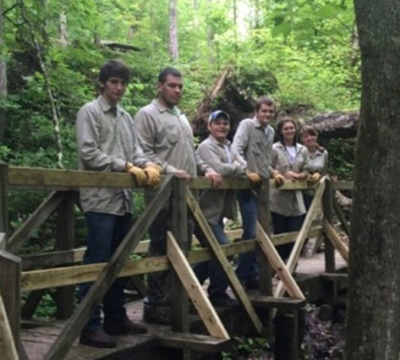Group of youth standing on footbridge on trail