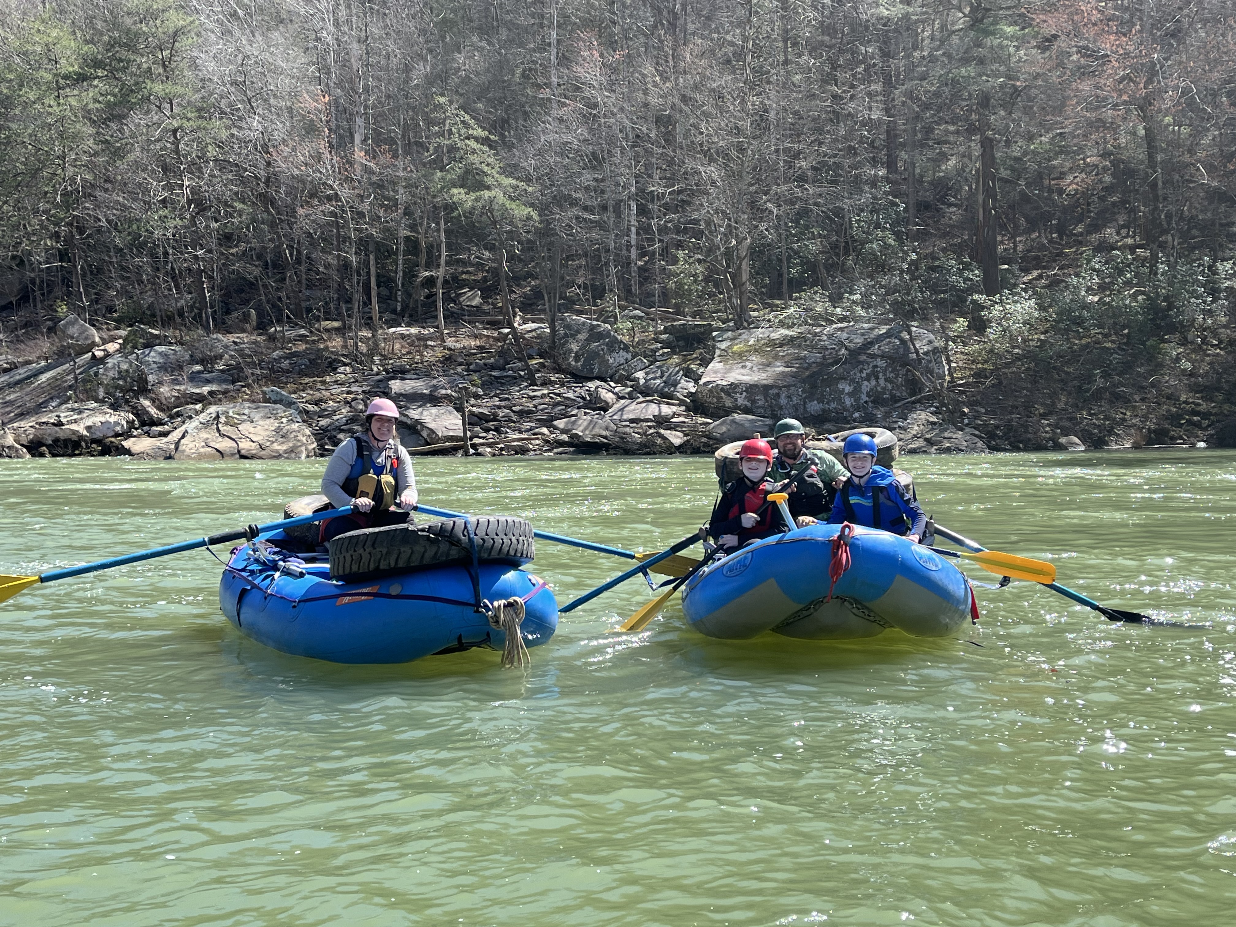Paddlers on boat in the river doing a cleanup.