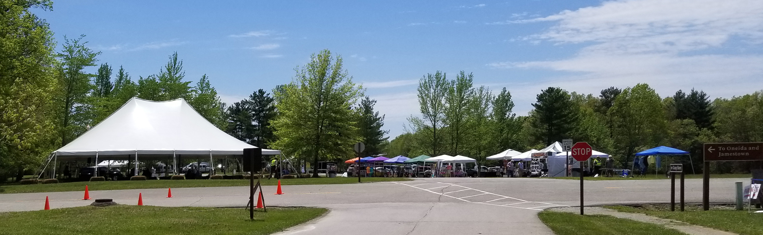 tents scatter across a green field with people walking around