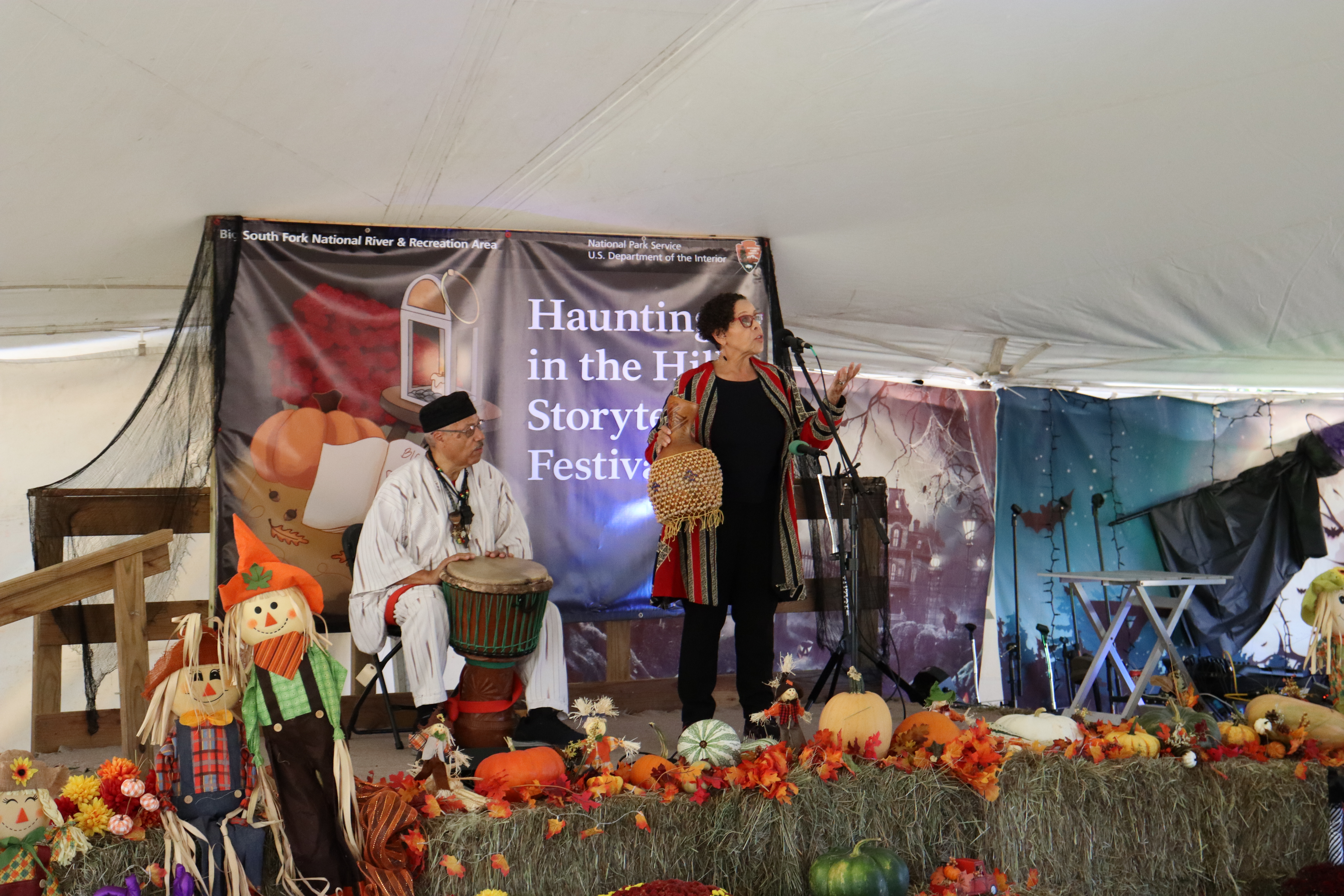 A male and female storytellers are on stage telling stories to a crowd.