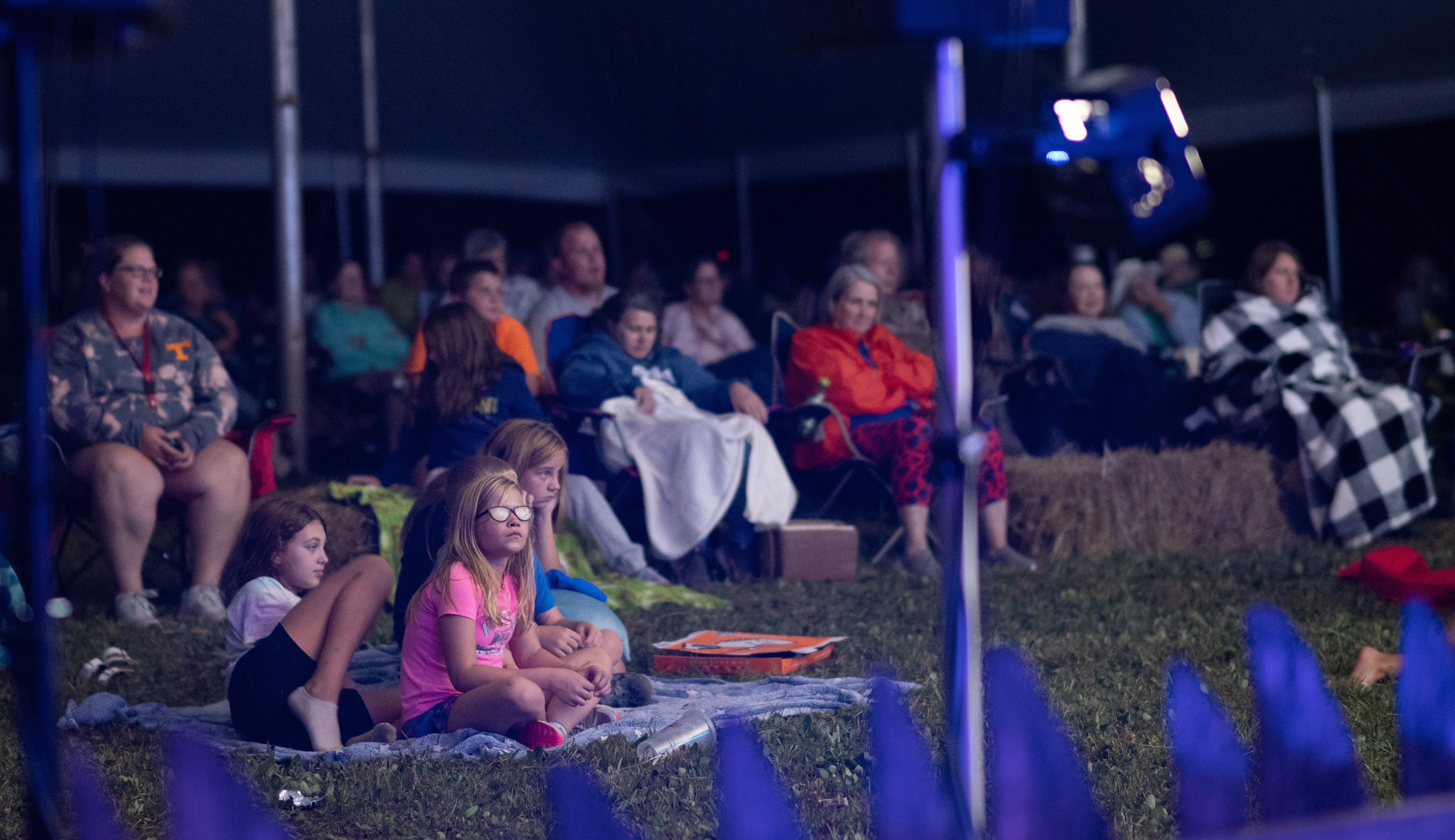 A crowd sitting in the evening listening to storytelling.