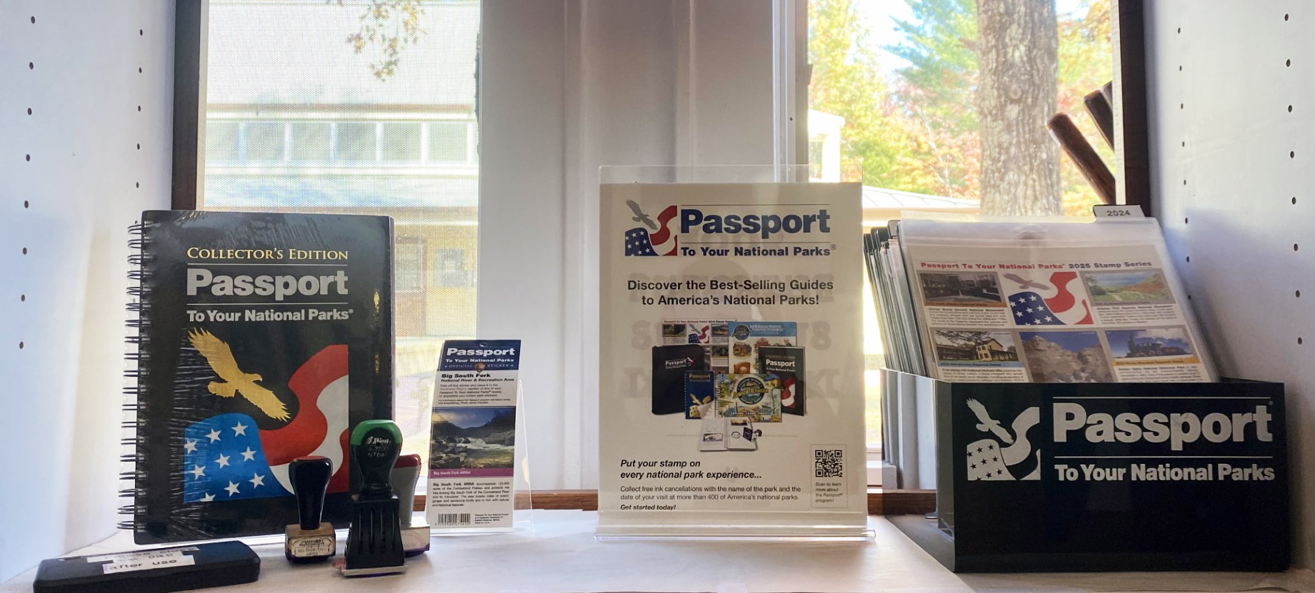 A display on a window shelf with the National Parks Passport Stamp Collection