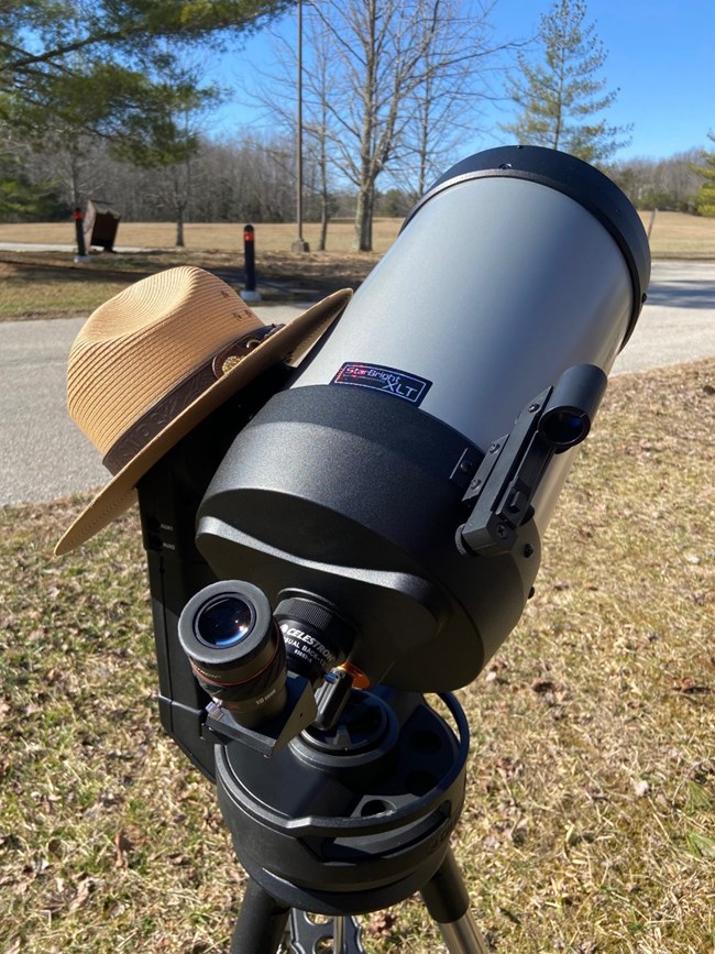 a telescope with a national park flat hat
