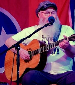 man sitting and playing guitar