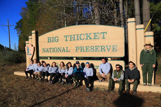 Volunteers and Park Staff standing in front of Big Thicket Visitor Center sign