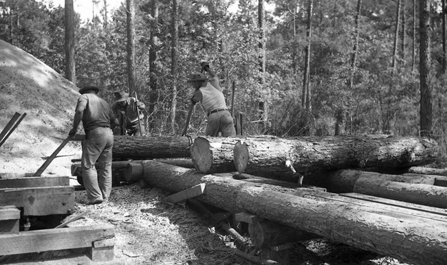 men sawing logs at a sawmill