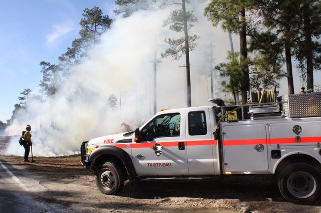 fire truck and firefighter on site of prescribed fire