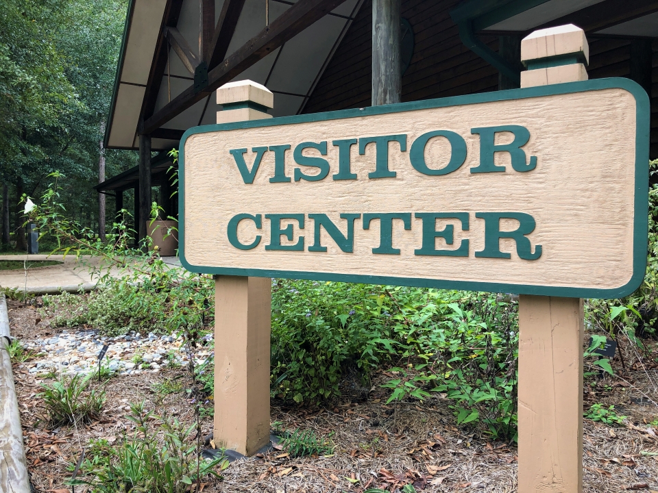wooden sign with text reading visitor center