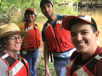 4 people taking a selfie while wearing personal flotation devices