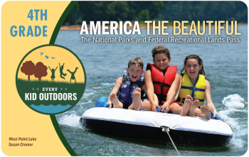 Graphic of America the Beautiful 4th Grade Pass with photo showing 3 smiling children wearing life jackets while riding a raft being pulled by a rope on a lake.