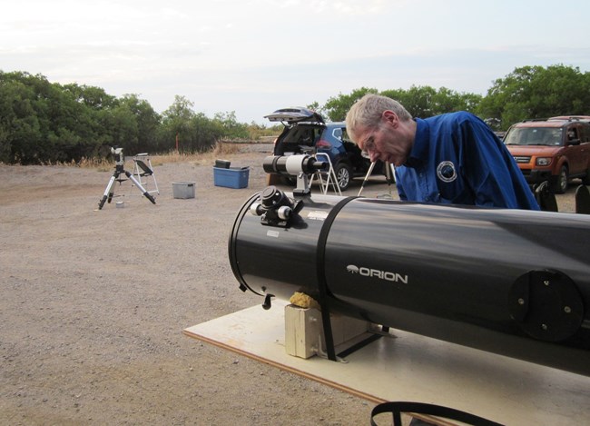 A person standing next to a telescope