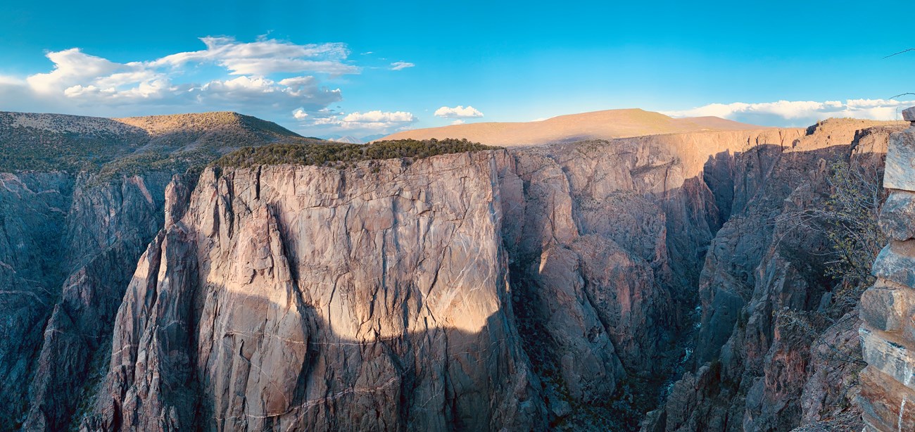 Image of a blue and yellow hued sunset view over a deep, steep canyon